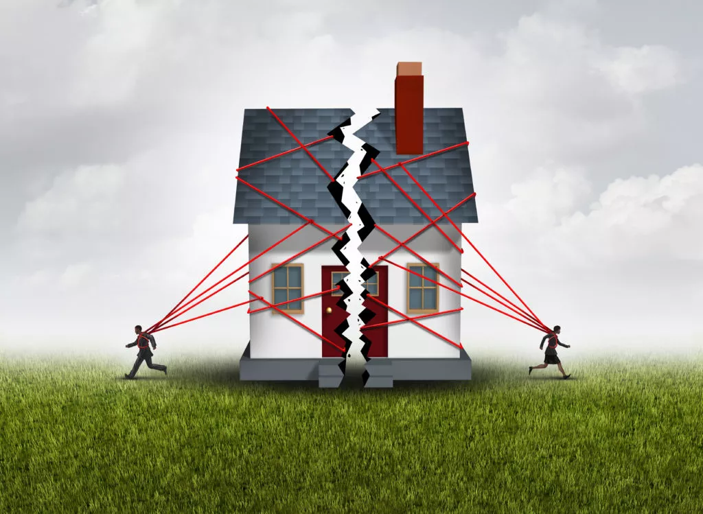 Image of two people running towards opposite sides with half a house tied with ropes behind them. Representation of Community Property and Divorce in Idaho